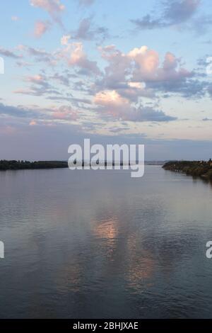 Ampio fiume Danubio con costa verde. Città in lontananza Foto Stock