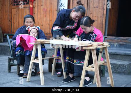 (200426) -- XIANGXI, 26 aprile 2020 (Xinhua) -- Shi Linjiao (i° R) impara il ricamo del gruppo etnico Miao al villaggio di Shibadong di Xiangxi Tujia e prefettura autonoma di Miao, provincia Hunan della Cina centrale, 25 aprile 2020. Shi Linjiao, 24 anni, è un villaggio montagnoso della provincia di Hunan, nella Cina centrale. Una volta lavorò alla pubblicità presso una società di Liuyang, anche una città di Hunan, dopo essersi laureata in un giardino d'inverno nel 2019. Tuttavia, con il suo sogno e uno spirito pionieristico in mente, Shi si dimise dalla società all'inizio del 2020, e tornò a Shib Foto Stock