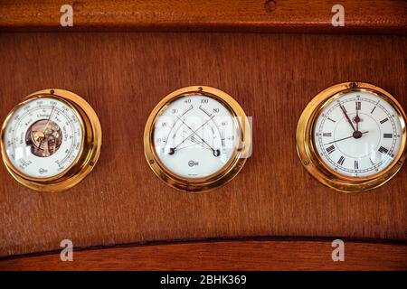 Un trio di strumenti nautici Barigo, termometro a barometro orologio igrometro, su una barca d'epoca Foto Stock