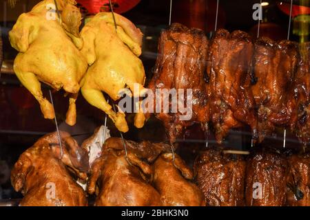 Anatre arrosto appese sulla vetrina rack nella cucina del ristorante Foto Stock