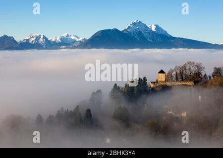 Vista del muro fortificato e della torre di guardia di Josefsturm nella nebbia con le montagne sullo sfondo, come si vede dalla fortezza di Festung Hohensalzburg, Salisburgo Foto Stock