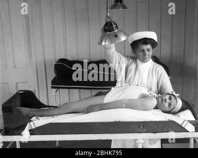 Bambini con Rickets che sono trattati in un sanitorium in Hampshire Inghilterra nel 1925 infermiera con bambino. Trattamento farmaco salute malnutrizione povera Gran Bretagna cura la terapia della luce nursing1930 Foto Stock