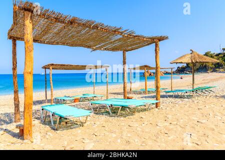 Lettini sulla spiaggia di Potami e sul mare blu, isola di Samos, Grecia Foto Stock