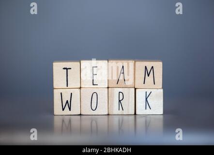Cubi in legno con le parole Team Work for business concept su sfondo grigio blu, lavorando insieme supporto Foto Stock