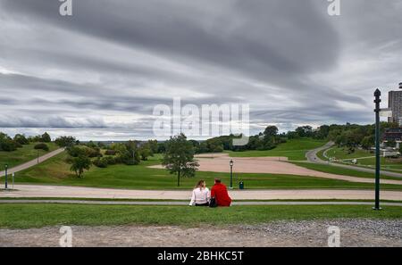 Coppia di uomini e donne seduti sul prato del Battlefield National Park a Quebec City. Foto Stock