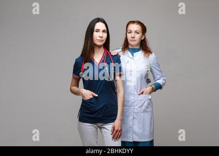 Due medici professionisti con stetoscopi, combattendo contro COVID-19 o coronavirus. Foto Stock