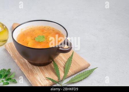 Ciotola di zuppa di cannabis fatta in casa su fondo in cemento chiaro con spazio per il testo Foto Stock