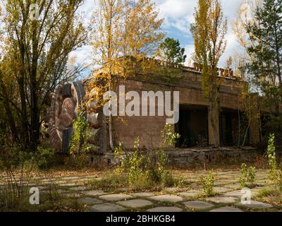 Edificio abbandonato del cinema a Pripyat. Area presa dalla natura e decadente. Zona di esclusione di Cernobyl. Ucraina Foto Stock