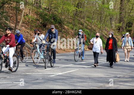 Persone e ciclisti, alcuni indossano maschere, a Prospect Park godendosi un caldo sole Sabato pomeriggio durante il coronavirus, Brooklyn, NY, 25 aprile 2020. Foto Stock