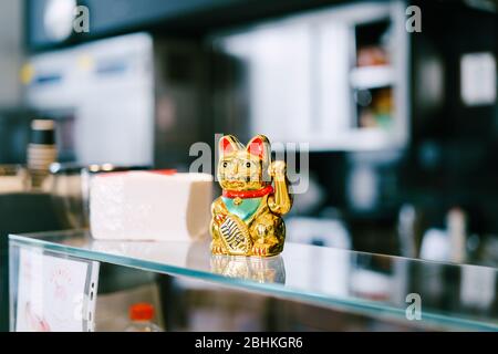 Tivat, Montenegro - 14 GIUGNO 2018: Maneki-neko figurine - invitante, beckoning, chiamata, felicità, denaro, buona fortuna gatto. Figurina giapponese di porcellana Foto Stock