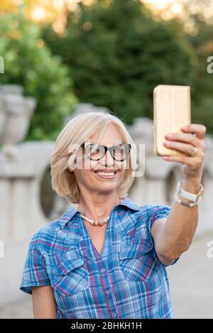 Bella donna senior tenendo selfie Foto Stock