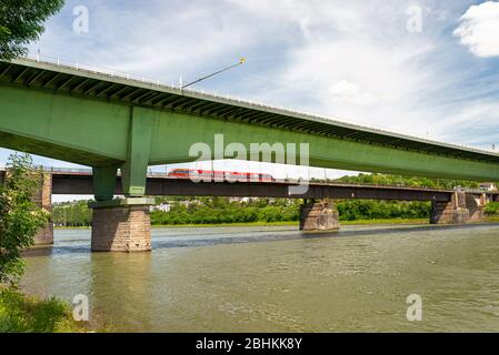 Un ponte autostradale in acciaio e un ponte ferroviario in cemento su un fiume nella Germania occidentale, con un cielo blu sullo sfondo. Foto Stock