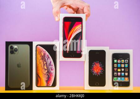 Parigi, Francia - 26 aprile 2020: Uomo che aggiunge l'ultima scatola se 2020 a più pacchetti schede di Apple computer iPhone smartphpone iPhone 3gs, se 2016, XS e 11 Pro Foto Stock