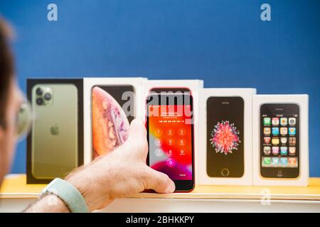 Parigi, Francia - 26 aprile 2020: Uomo che sbloccherà con touch id l'ultimo se 2020 con più pacchetti schede di Apple computer iPhone smartphpone iPhone 3gs, se 2016, XS e 11 Pro Foto Stock