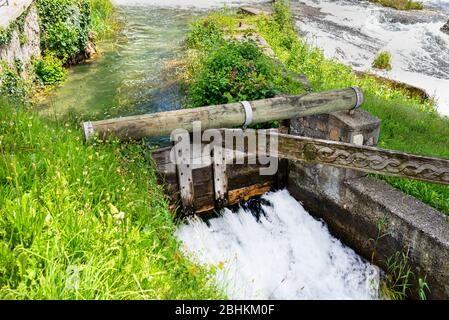 Una piccola diga sul bacino del fiume fatta di legno che richiede operazione manuale. Foto Stock