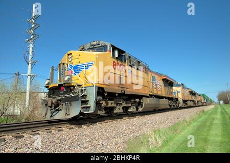 Ginevra, Illinois, Stati Uniti. Quattro locomotive che conducono un treno merci di auto impilate o container in un viaggio verso ovest da Chicago. La linea multi-traccia li Foto Stock
