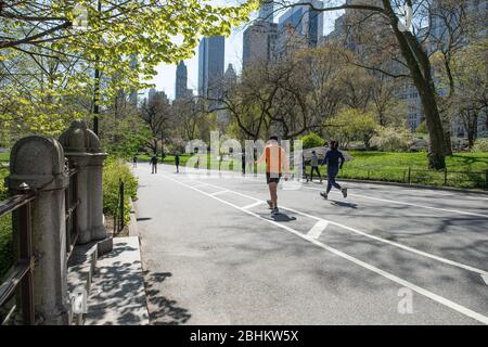 Corridori a Central Park, New York City, praticando le distanze sociali durante la Pandemia di Coronavirus. Foto Stock