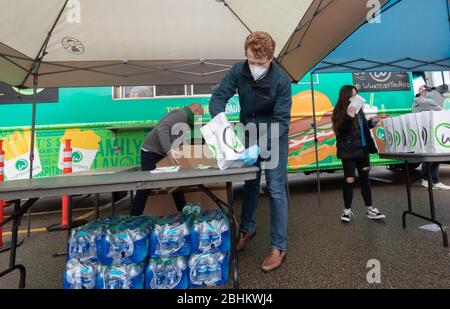 24 aprile 2020, Norwood, Massachusetts, USA: Rappresentante degli Stati Uniti Joe Kennedy III (D-ma) che si prepara con il personale di Whalburgers per distribuire i pasti ai membri di Teamsters Local 25 che guidano per UPS, al di fuori di UPS Norwood. Whalburgers è di proprietà dello chef Paul Wahlberg, fratello di Donnie e Mark Wahlberg. Foto Stock