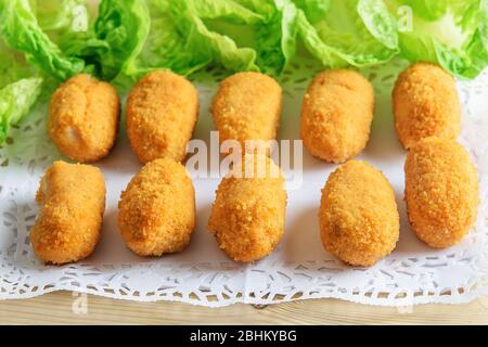 Crocchette e lattuga fresca verde sul piatto bianco. Fast food leggero e leggero. Foto Stock