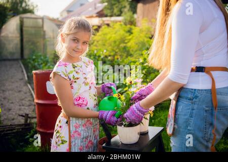 Giovane bella donna con figlia carina in giardino in estate sorridente felice, stile di vita concetto di persone Foto Stock