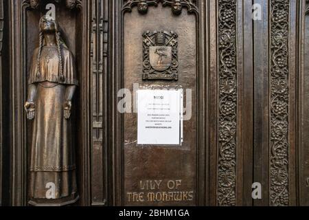 NEW YORK CITY - 19 APRILE 2020: La Cattedrale di San Patrizio nel centro di Manhattan si trova vuota con un cartello sulle porte durante il Covid-19 Coronavirus pa Foto Stock