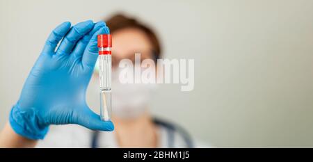 Test per il coronavirus Covid-19. Medico o infermiere che esegue analisi di laboratorio di un tampone nasale in un laboratorio ospedaliero. Tecnico medico che tiene un kit di strisci COVID-19, indossando guanti di protezione da Foto Stock