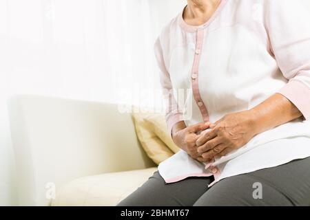 dolore allo stomaco della vecchia donna a casa, problema sanitario del concetto senior Foto Stock