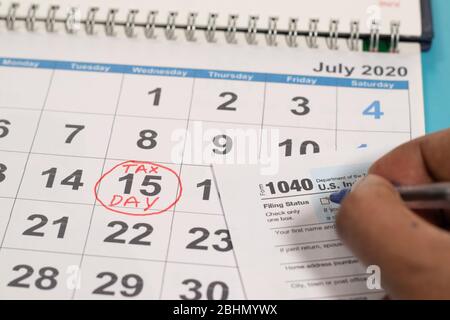 Concetto di compilazione del modulo fiscale prima della scadenza del 15 luglio con il 15 luglio contrassegnato come giorno fiscale sul calendario come sfondo. Foto Stock