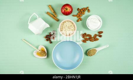 Sana preparazione della colazione creativa composizione concetto con avena, spezie, yogurt, frutta fresca, noci, miele e alta fibra LSA sul retro moderno verde Foto Stock