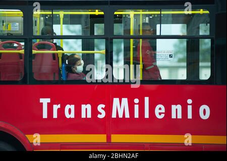 Le persone che utilizzano Transmilenio, il principale trasporto cittadino di Bogotà, sono viste indossare una maschera protettiva per il viso e guanti chirurgici durante la quarantena che Foto Stock