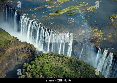 Cascate Vittoria o 'mosi-oa-Tunya' (il fumo che Thunders), e fiume Zambesi, Zimbabwe / confine Zambia, Africa Meridionale - aereo Foto Stock