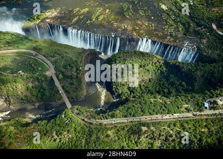 Cascate Vittoria o 'mosi-oa-Tunya' (il fumo che Thunders), fiume Zambesi, e Victoria Falls Bridge, Zimbabwe / confine con Zambia, Africa Meridionale - aer Foto Stock