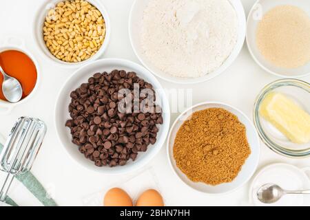 Le patatine di cioccolato e gli ingredienti per cuocere devono essere vicini su un tavolo da cucina. Ricetta dei biscotti del chip del cioccolato Foto Stock