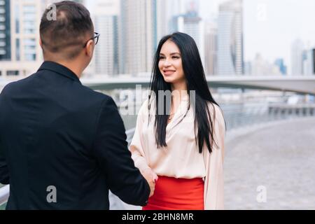 uomini d'affari che si scuotono le mani con il background della città Foto Stock