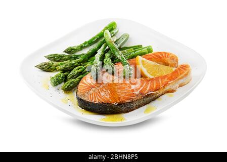 Asparagi appena sfornati e bistecca di salmone al forno con salsa di condimento sul piatto Foto Stock