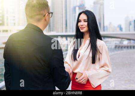 uomini d'affari che si scuotono le mani con il background della città Foto Stock