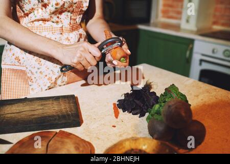 Soggiorno a casa donna che prepara e cucina vegetariana cibo Foto Stock