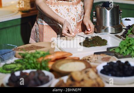 Soggiorno a casa donna che prepara e cucina vegetariana cibo Foto Stock