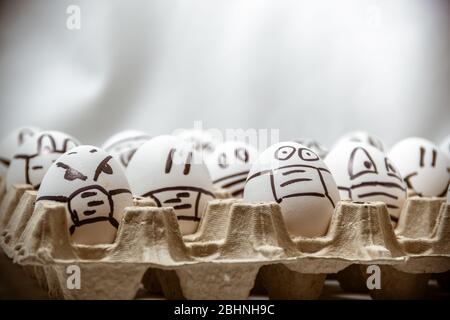 Concetto di distanza sociale covid 19. Primo piano di disegni volti con maschere mediche su set di uova di Pasqua. Copia spazio. Foto Stock