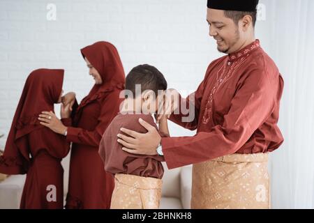 I membri della famiglia musulmana che si scuotono le mani per scusarsi e augurare Ramadan Kareem Foto Stock