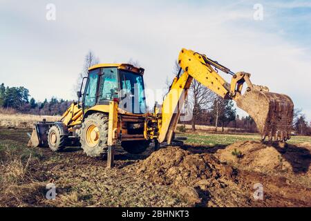 L'escavatore libera il terreno per spianare la strada in un territorio privato. 2019 Foto Stock