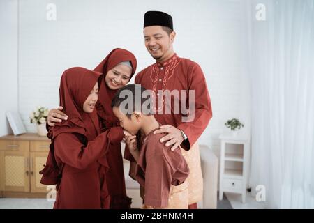 Tutti i membri della famiglia asiatica si scuotono le mani per scusarsi e augurare Ramadan Kareem Foto Stock