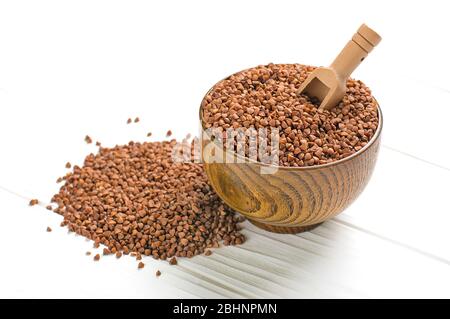 Grani di grano saraceno marrone in ciotola di legno su sfondo bianco isolato cibo sano, concetto di superfood Foto Stock