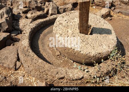 Millstone in Gamla antica città ebraica sulle alture del Golan. Foto Stock