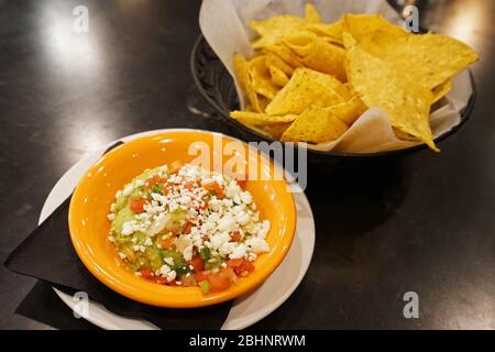 Primo piano formaggio Nacho servito con guacamole - cibo messicano Foto Stock