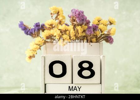 Calendario cubo bianco per maggio decorato con fiori su sfondo verde con spazio copia Foto Stock