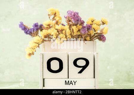 Calendario cubo bianco per maggio decorato con fiori su sfondo verde con spazio copia Foto Stock