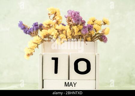 Calendario cubo bianco per maggio decorato con fiori su sfondo verde con spazio copia Foto Stock