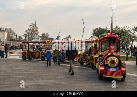 Persone e turisti in un trenino con partenza per il tour del centro storico di Bardolino sulle rive del Lago di Garda, Verona, Veneto, Italia Foto Stock