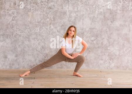 Ragazza Tennage fare ginnastica fitness a casa. Tutorial video ginnastica. Esercizi ginnici. Attività dei bambini in quarantena durante il coronavirus pa Foto Stock